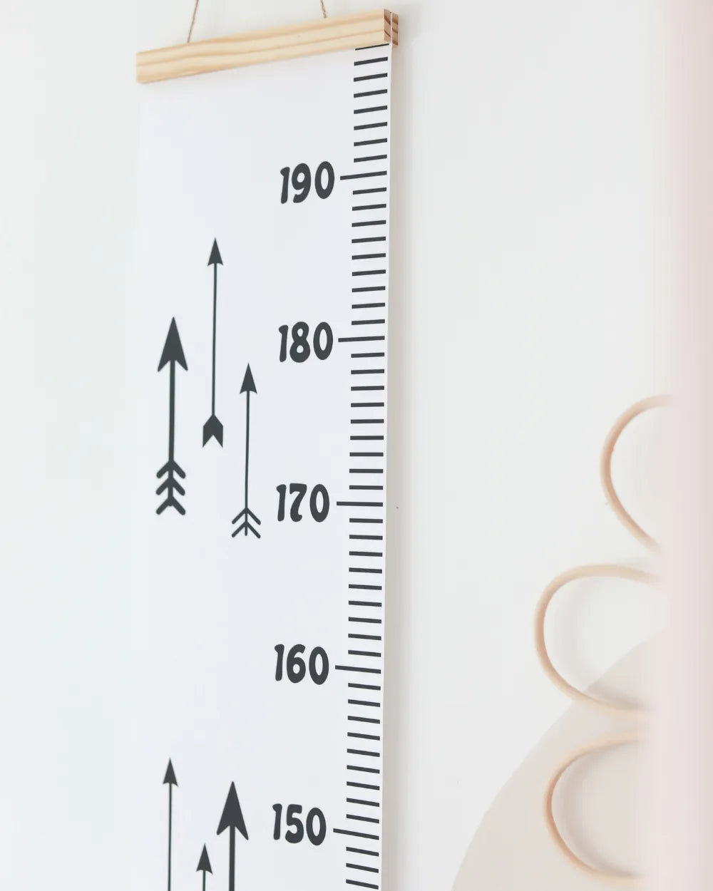 a growth chart hanging on a wall next to a clock