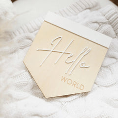 a close up of a wooden sign on a white blanket