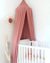 a baby's room with a pink canopy and a white crib