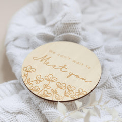 a close up of a wooden brooch with a name on it