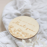 a close up of a wooden brooch with a name on it