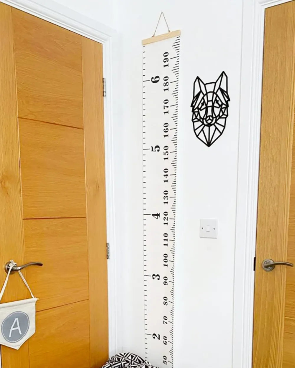 a room with a wooden door and a ruler on the wall