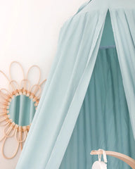 a bed with a canopy and a mirror on the wall