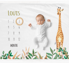 a baby is laying on a calendar with a giraffe