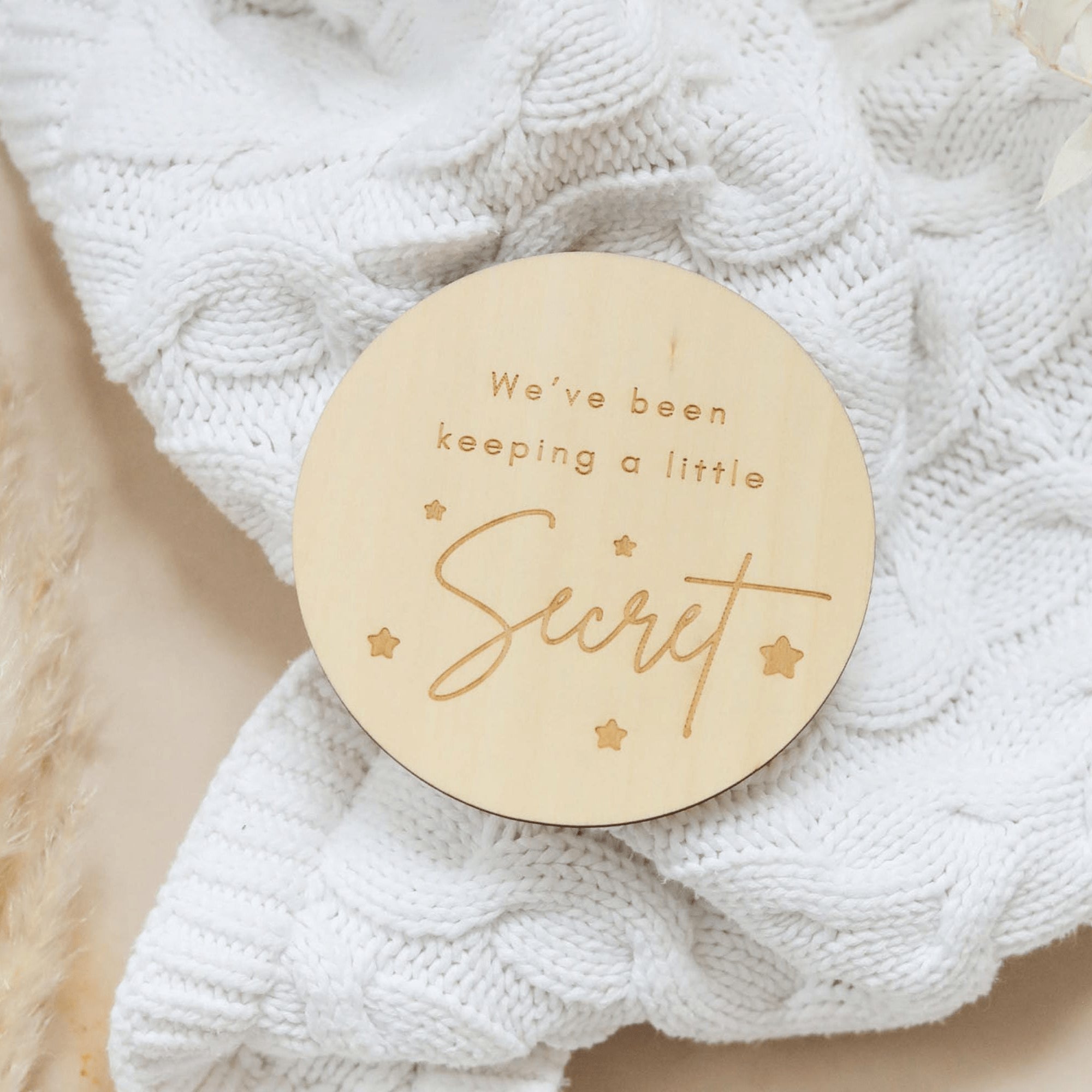 a wooden badge that says, we've been keeping a little secret