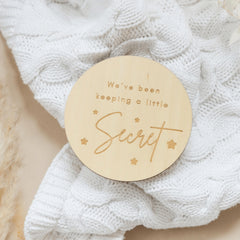 a wooden badge that says, we've been keeping a little secret