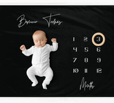 a baby is laying down on a calendar