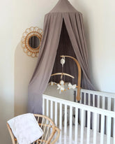 a baby crib with a canopy and a chair