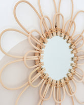 a circular mirror made of wood sticks and a circular mirror