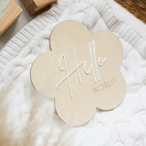 a close up of a wooden sign on a blanket