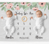 two baby babies are laying on a blanket