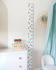 a child's room with a white dresser and a blue curtain