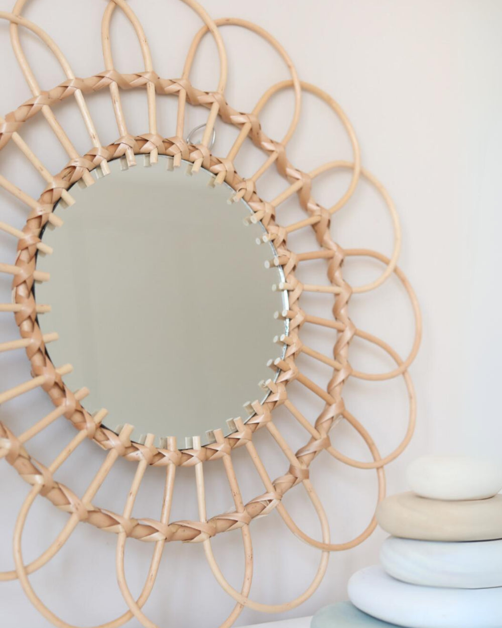 a round mirror sitting on top of a wooden table