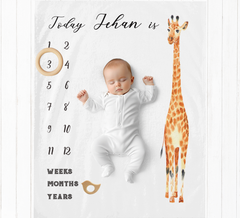 a baby is laying down next to a giraffe