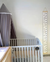 a baby crib with a measuring tape next to it