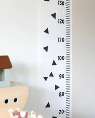 a child's room with a white wall and a black and white growth chart