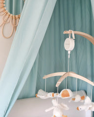 a baby crib with stuffed animals hanging from it