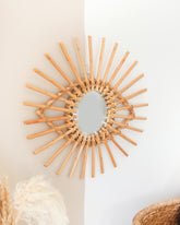 a sun shaped mirror hanging on a wall