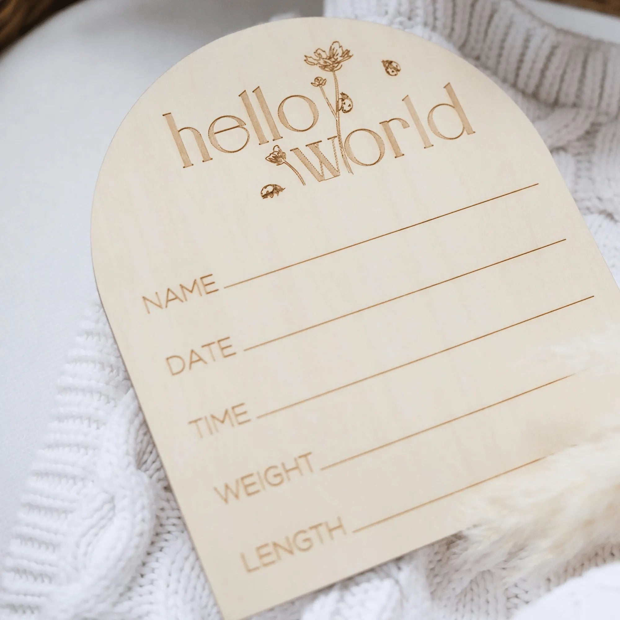 a wooden name tag attached to a white sweater