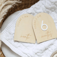 a couple of wooden tags sitting on top of a white blanket