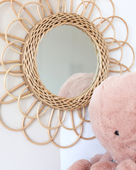a pink teddy bear sitting in front of a mirror