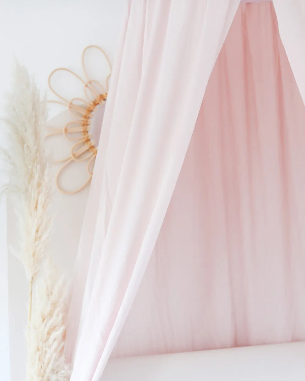 a bed with a pink canopy and white curtains