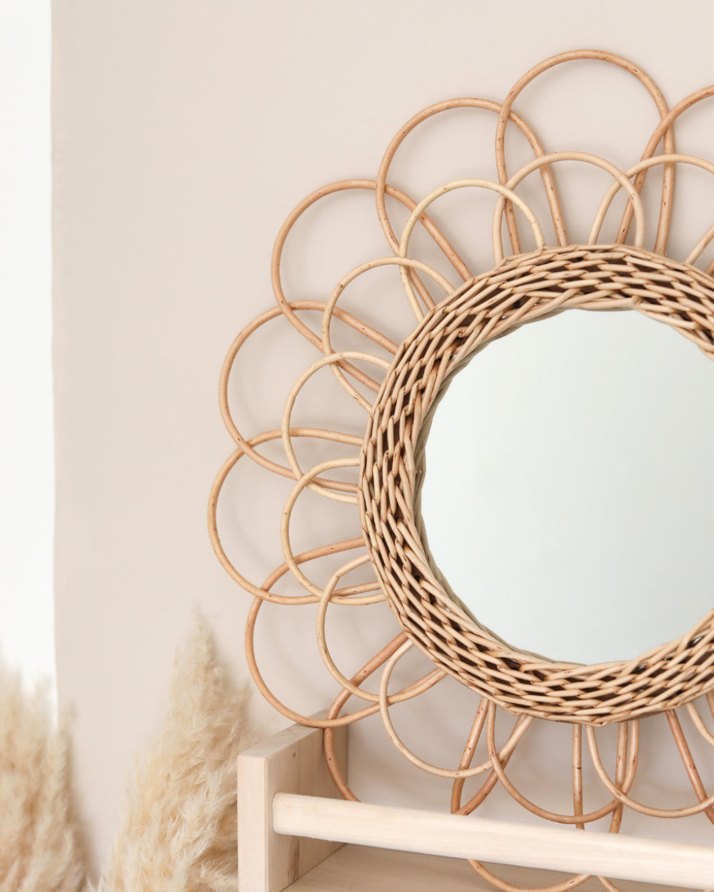 a round mirror sitting on top of a wooden shelf