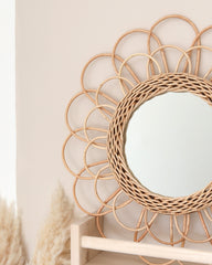 a round mirror sitting on top of a wooden shelf