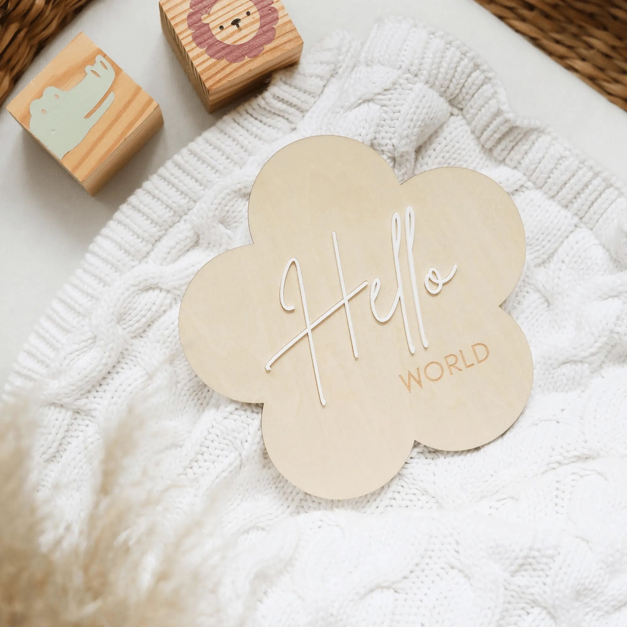 a white blanket with a wooden hello world sign on it