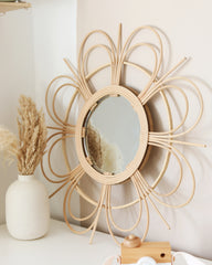 a mirror on a wall next to a vase
