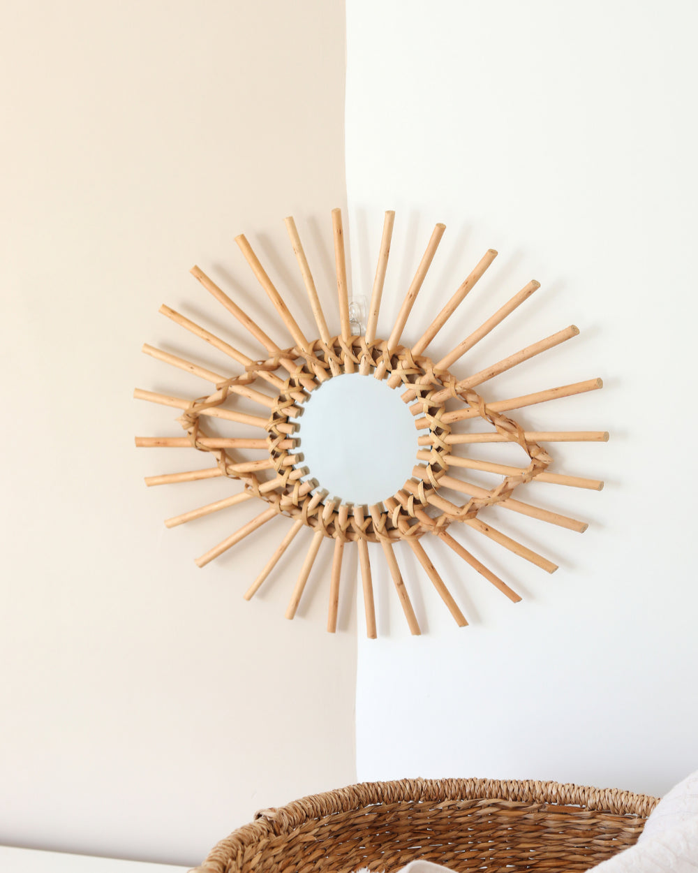 a sun shaped mirror hanging on a wall