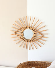 a sun shaped mirror hanging on a wall