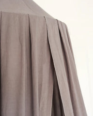 a close up of a person wearing a gray shirt