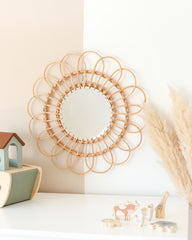 a round mirror on a wall next to a toy house